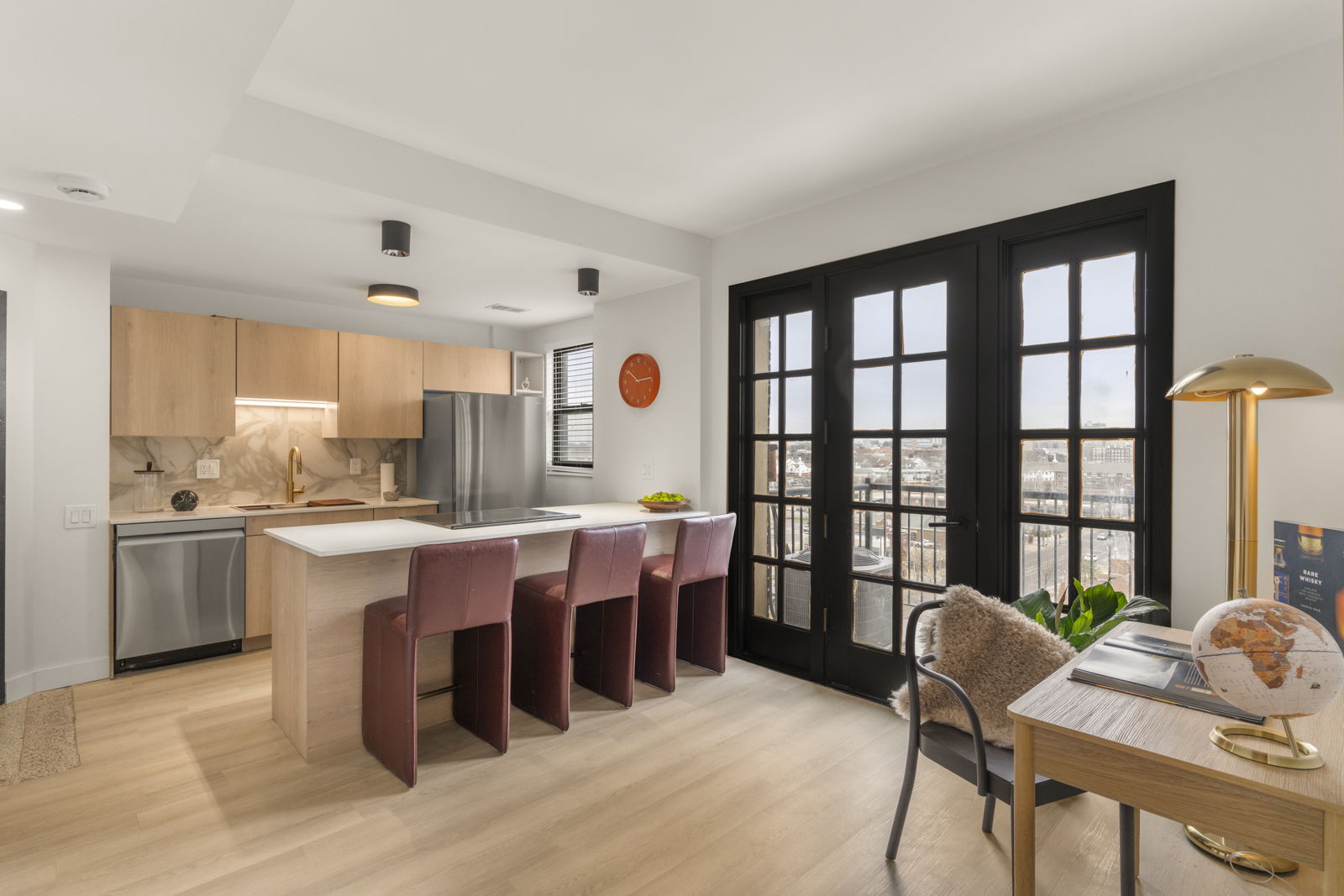 Open living area at The Harper with floor-to-ceiling French doors and city views
